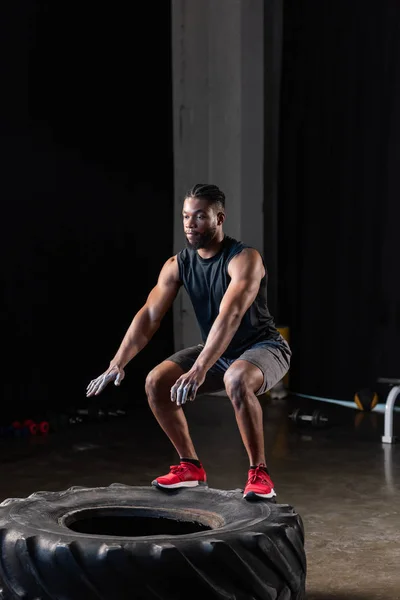 健身运动中的非裔美国男子在运动轮胎运动中的全长观 — 图库照片