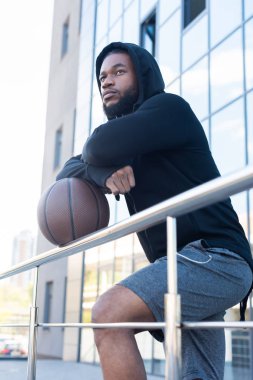 basketbol topu eğilerek ve uzağa sokakta seyir dalgın Afrikalı-Amerikalı adam