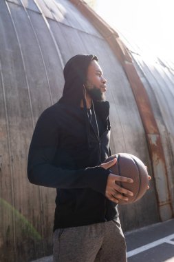 yakışıklı genç Afro-Amerikan adam sokakta basketbol topu tutan