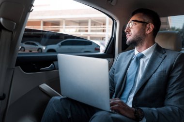 gözlük ile laptop uzakta araba arka koltuğa bakıp dalgın işadamı