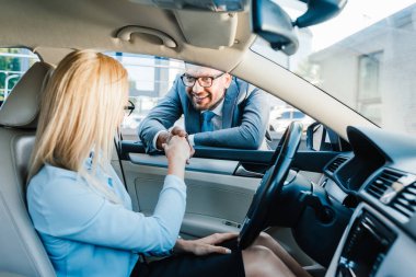 işadamı ve el sallayarak araba meslektaşım gülümseyen