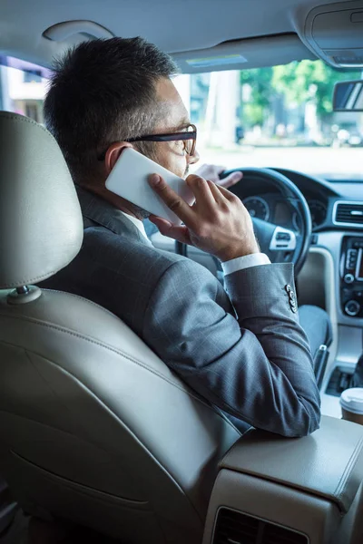 Вид Сзади Бизнесмена Разговаривающего Смартфону Рулем Автомобиля — Бесплатное стоковое фото