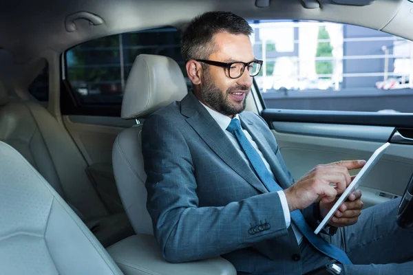 Μερική Άποψη Του Χαμογελώντας Επιχειρηματία Γυαλιά Χρησιμοποιώντας Tablet Στο Αυτοκίνητό — Φωτογραφία Αρχείου
