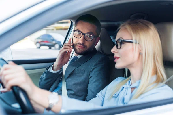 Foco Seletivo Empresária Dirigindo Carro Enquanto Colega Falando Smartphone Perto — Fotografia de Stock