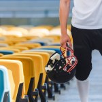 Colpo ritagliato di giocatore di football americano in piedi sulle scale dello stadio sportivo