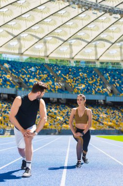 genç atletik çift koşu parkuru, spor stadyum üzerinde koşu önce bacaklarını ısınma