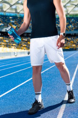 sporcu spor stadyumunda su şişeyle kadeh kırpılmış