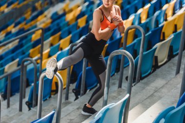 uygun genç kadının spor Stadyumu'nda tribünler üzerinde uzanan yüksek açılı görünüş