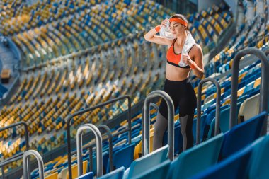 yorgun genç kadının spor stadyumunda havlu ile yüksek açılı görünüş