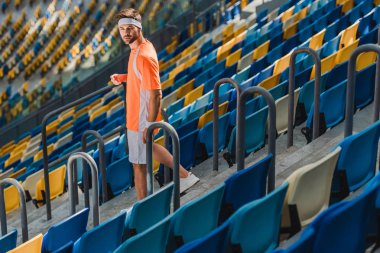 alt kattaki spor stadyumunda merdivenlerde yürüyen sportif genç adam