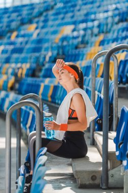 Merdivenlerde rahatlatıcı ve spor Stadı'nda ter silerek yorgun genç kadın yan görünüm