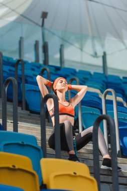spor stadyumunda merdivenlerde güzel genç kadının rahatlatıcı alttan görünüm