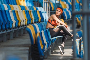 güzel ve genç birbayan tribün spor stadyumunda otururken yan görünüm