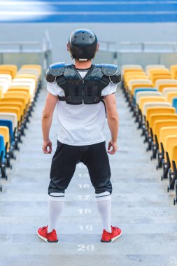 atletik Amerikan futbolu oyuncusu spor stadyumunda merdivenlerde dikiz