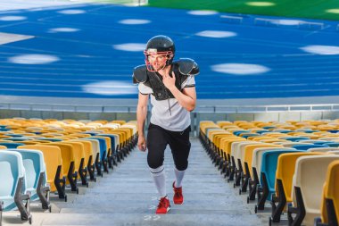 spor stadyumunda yukarı gidiş yakışıklı genç Amerikan futbolu oyuncusu