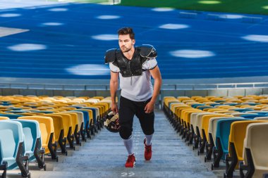 spor stadyumunda yukarı gidiş atletik genç Amerikan futbolu oyuncusu