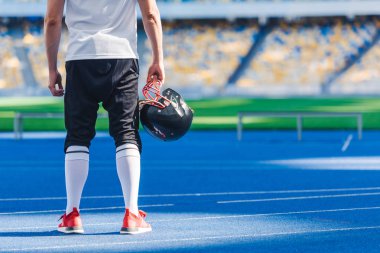 Amerikan futbolu oyuncusu kask ayakta ile çekim spor Stadı'nda yalnız kırpılmış
