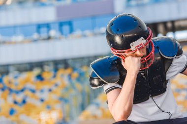 spor Stadı'nda oturan üzgün genç Amerikan futbolu oyuncusu