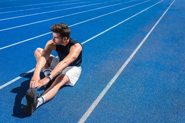 Knappe Jongeman Die Zich Uitstrekt Atletiekbaan — Stockfoto