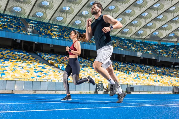 体育场馆田径运动中青年男女慢跑的动作镜头 — 图库照片