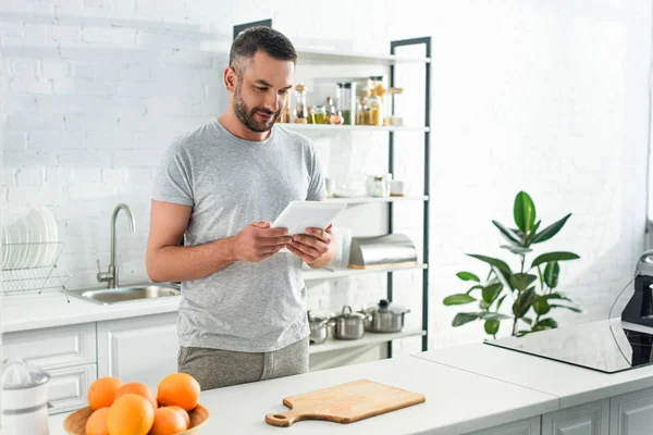 Pria Dewasa Tersenyum Dengan Tablet Digital Mencari Resep Dekat Meja — Foto Stok Gratis