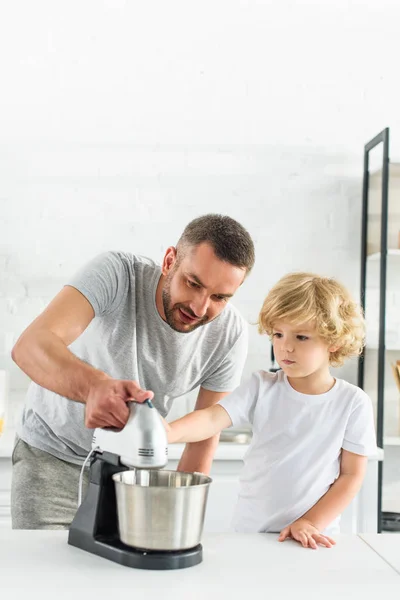 Otec Učí Syna Pomocí Mixéru Stole Kuchyni — Stock fotografie