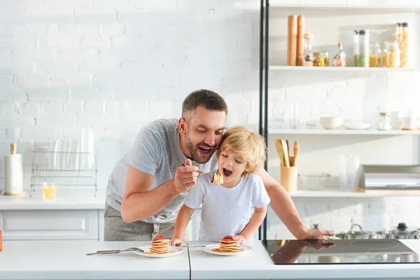 Lycklig Far Och Son Äta Pannkakor Köket — Stockfoto