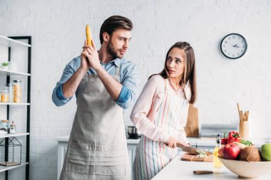 kız kesme sebze ve yakışıklı erkek eğleniyor muz silah ile mutfakta