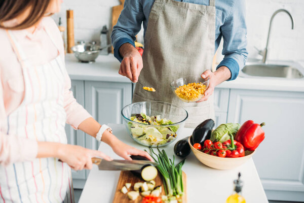 cropped image of couple cooking together in kitchen
