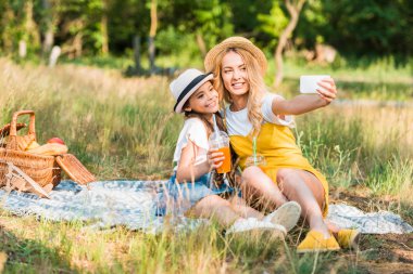 mutlu anne ve kızı alarak selfie ile smartphone piknik
