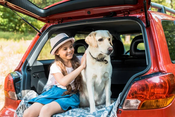 Schattig Kind Knuffelen Hond Auto Kofferbak — Stockfoto