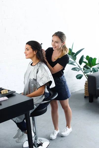 Vista Lateral Sorrindo Cabeleireiro Com Pente Fazendo Penteado Para Mulher — Fotografia de Stock