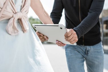 cropped view of male robbery stealing laptop from womans hands clipart