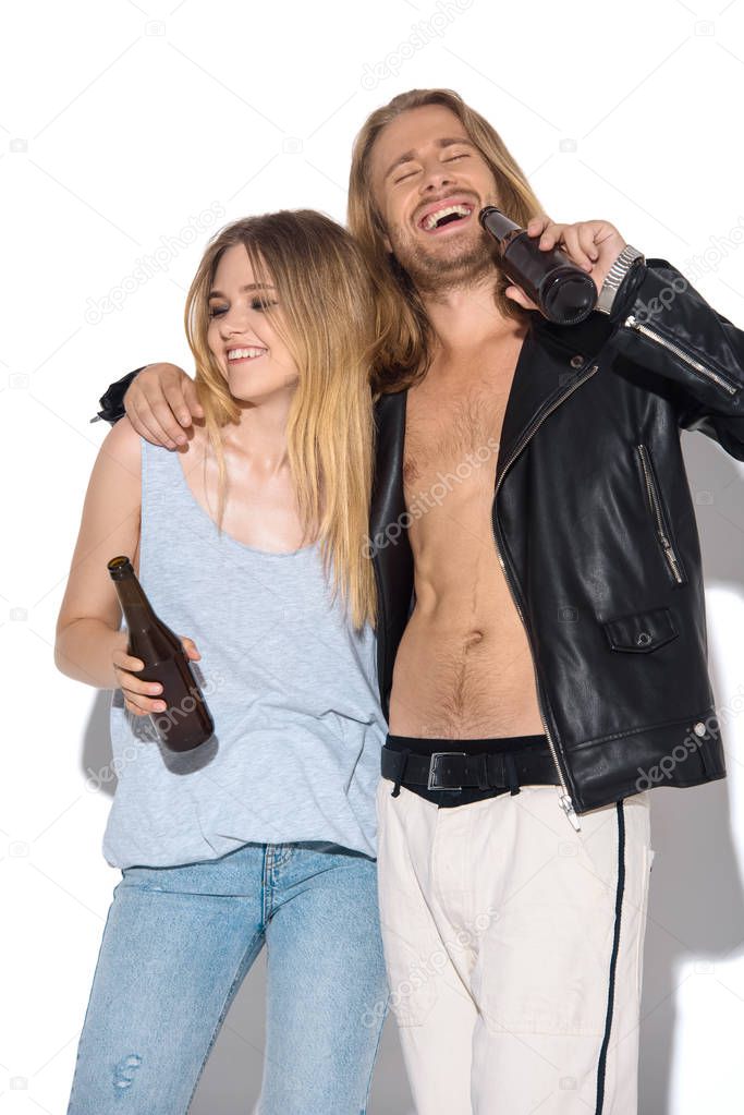 young happy and drunk couple with bottles of beer on white