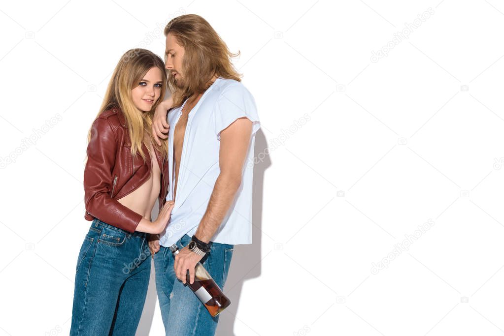 stylish young drunk couple with bottle of rum on white