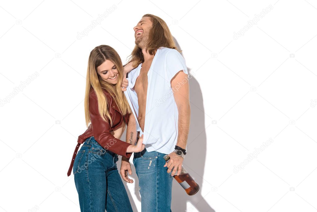 young drunk couple with bottle of rum undressing on white