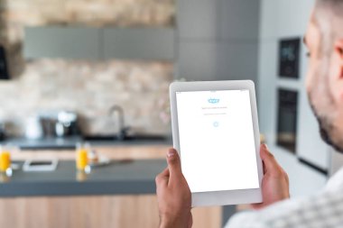 skype logo üstünde perde mutfak ile dijital tablet kullanan adam seçici odak 