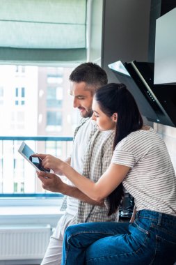 evli çift dijital tablet birlikte mutfak, akıllı ev concept kullanma yan görünüm