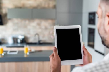 seçici odak bir tablet ile boş perde mutfak elinde tutan adam