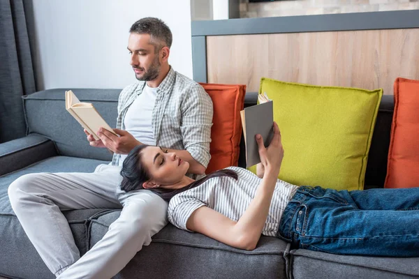 Pareja Enfocada Leyendo Libros Sofá Casa —  Fotos de Stock