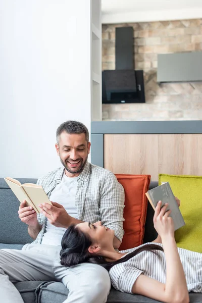 Smiling Couple Looking Each Other While Reading Books Couch Home — Stock Photo, Image