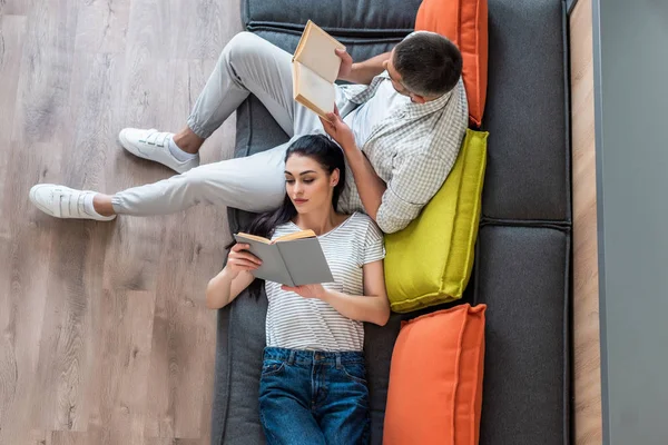 Evde Kanepede Kitap Okuma Çift Havai Görünümü — Stok fotoğraf