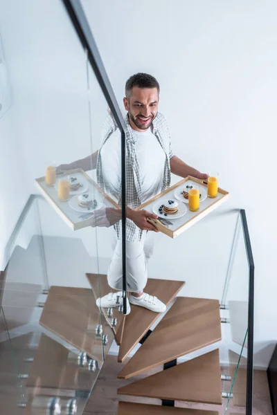 Hombre Sonriente Con Desayuno Bandeja Madera Subiendo Escaleras Casa — Foto de Stock