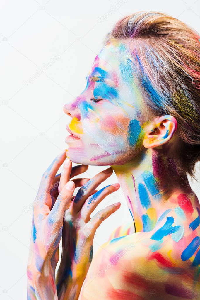 side view of attractive girl with colorful bright body art touching chin isolated on white 