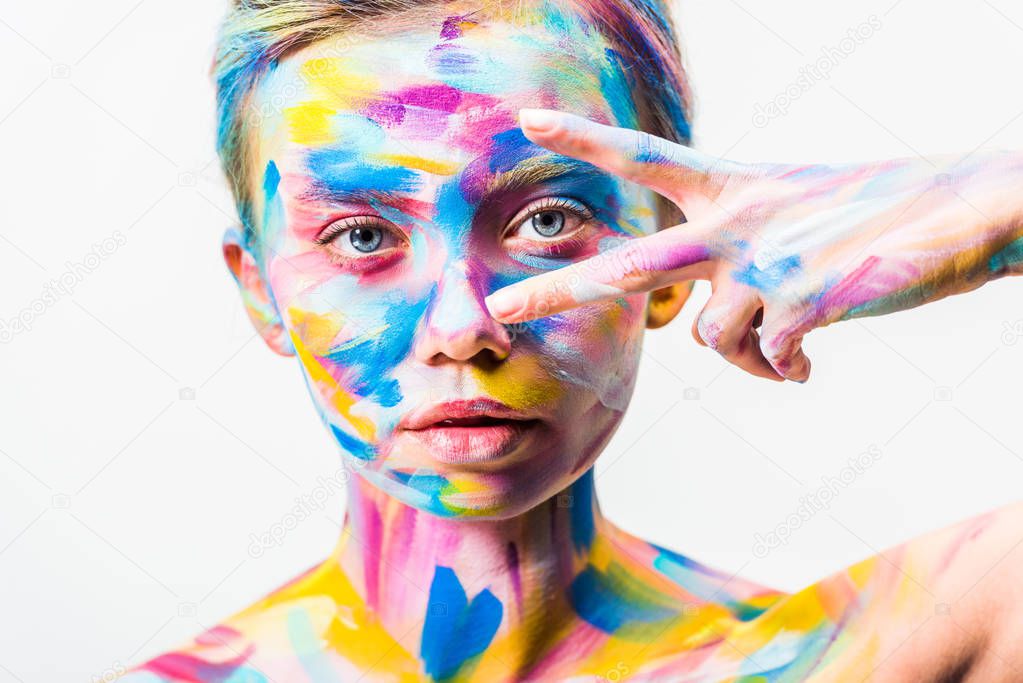 attractive girl with colorful bright body art looking at camera through two fingers isolated on white  