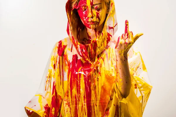 Femme Imperméable Peint Avec Des Peintures Jaunes Rouges Montrant Majeur — Photo gratuite