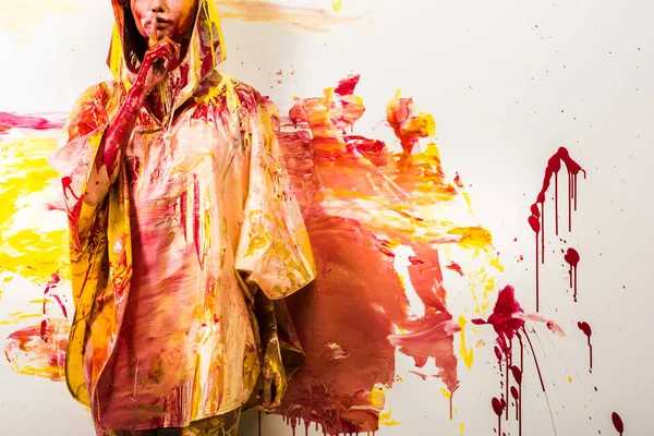 妇女的裁剪的图片与黄色和红色的油漆画的雨衣显示沉默的手势 — 图库照片