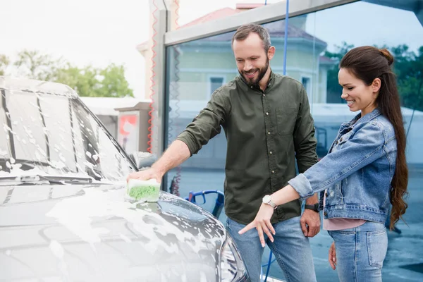 Fidanzata Che Punta Sulla Macchina Fidanzato Mentre Pulisce All Autolavaggio — Foto Stock