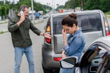 upset man and woman near cars after car accident clipart