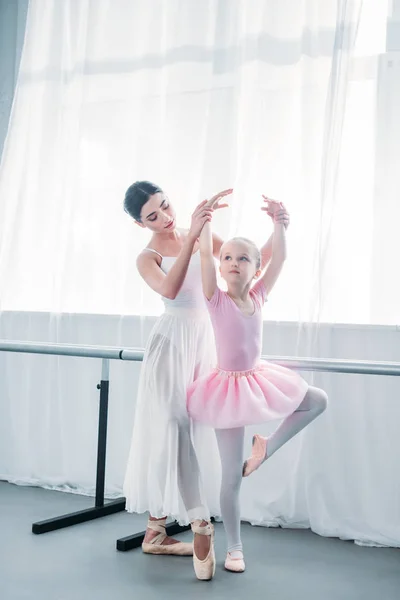Urocze Dziecko Różowe Tutu Praktykujących Balet Młodym Nauczycielem Szkole Baletowej — Zdjęcie stockowe